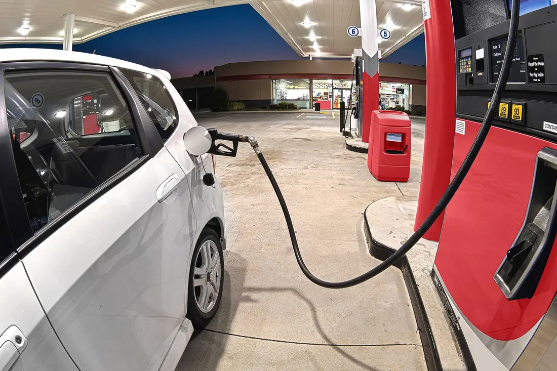 A car at a filling-station pump, ready for the road.